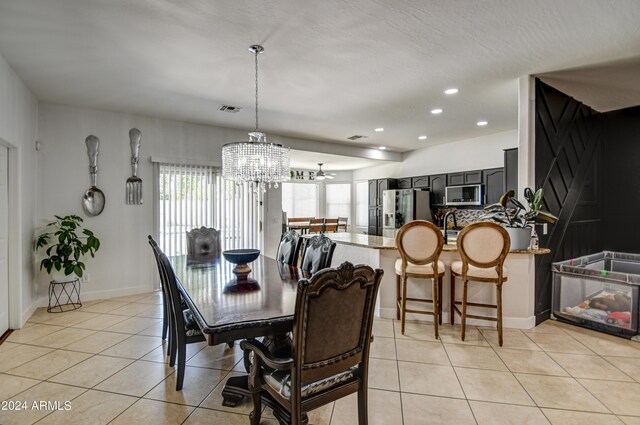 dining space featuring light tile patterned flooring and a notable chandelier