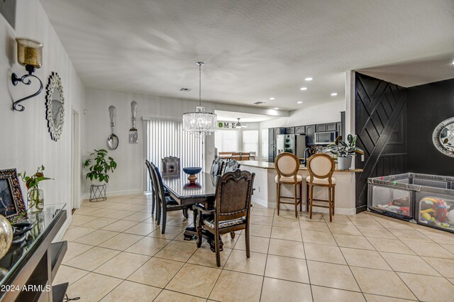 dining area with light tile patterned flooring and a notable chandelier