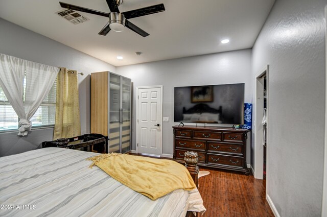 bedroom with dark hardwood / wood-style floors and ceiling fan