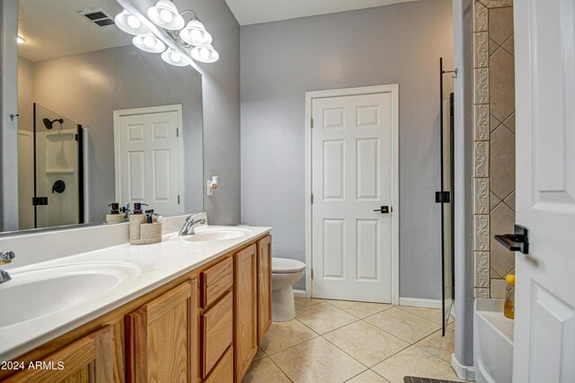 bathroom featuring toilet, tile patterned floors, and double vanity