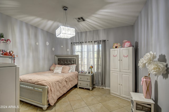 tiled bedroom featuring an inviting chandelier