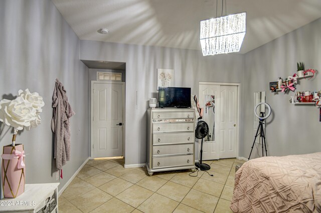 bedroom featuring a notable chandelier, a closet, and light tile patterned floors