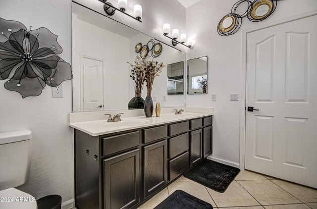 bathroom featuring tile patterned floors, double vanity, and toilet