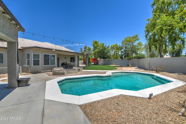 view of pool with a patio and an outdoor fire pit