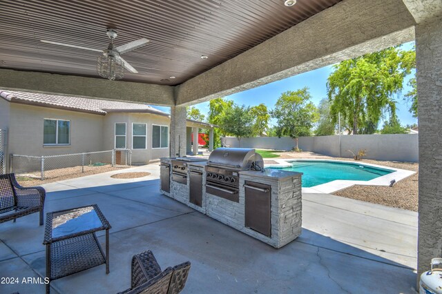 view of patio / terrace with ceiling fan, a fenced in pool, a grill, and exterior kitchen