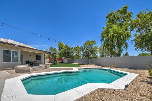 view of swimming pool featuring a patio and an outdoor fire pit