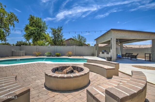 view of swimming pool featuring a patio, ceiling fan, and an outdoor fire pit