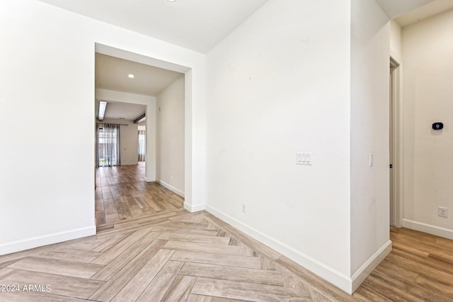 corridor featuring parquet floors and baseboards