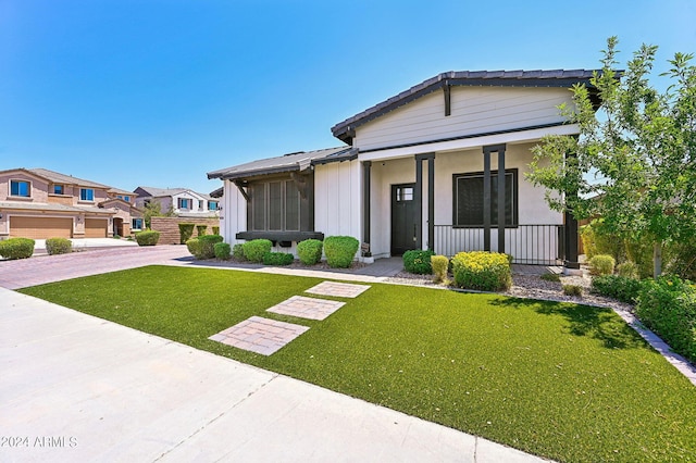 view of front of house with a porch, a front lawn, and board and batten siding