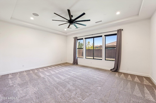 carpeted spare room with baseboards, a raised ceiling, a ceiling fan, and recessed lighting