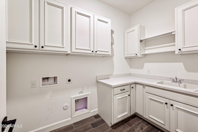 washroom featuring cabinet space, hookup for an electric dryer, wood finish floors, washer hookup, and a sink