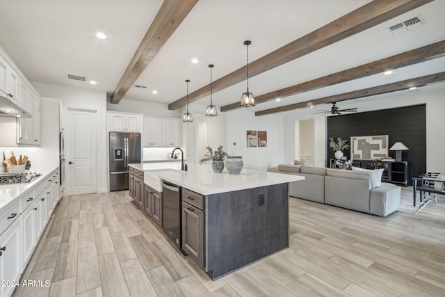 kitchen with light countertops, visible vents, appliances with stainless steel finishes, white cabinets, and a sink