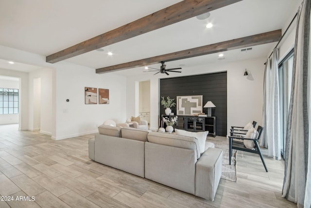 living area featuring wood finish floors, beamed ceiling, and baseboards