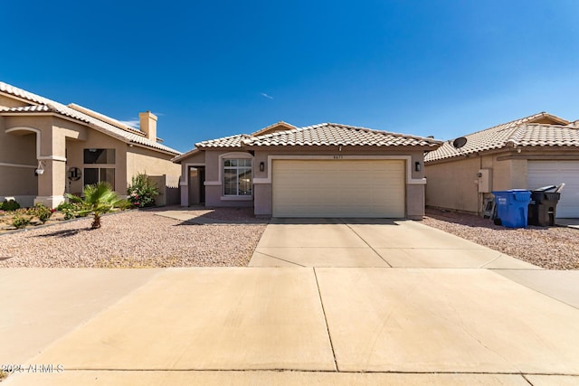 8673 W Palm Ln, Phoenix, AZ 85037 - mediterranean / spanish house with stucco siding, an attached garage, driveway, a tile roof, and a chimney