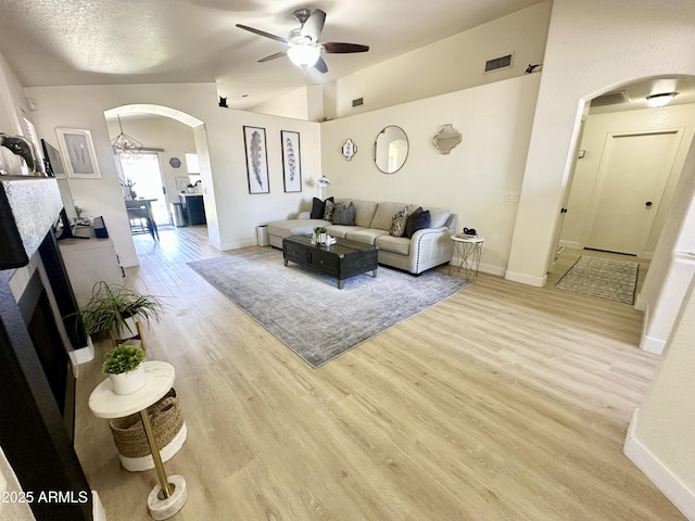 8673 W Palm Ln, Phoenix, AZ 85037 - living area featuring arched walkways, ceiling fan, light wood-style floors, and vaulted ceiling