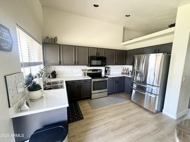 8673 W Palm Ln, Phoenix, AZ 85037 - kitchen featuring appliances with stainless steel finishes, backsplash, light countertops, light wood-style floors, and high vaulted ceiling