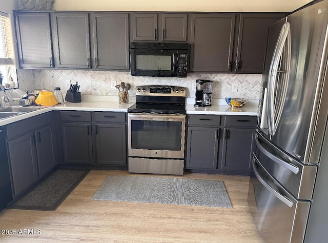 8673 W Palm Ln, Phoenix, AZ 85037 - kitchen with stainless steel appliances, light countertops, light wood-style flooring, and decorative backsplash