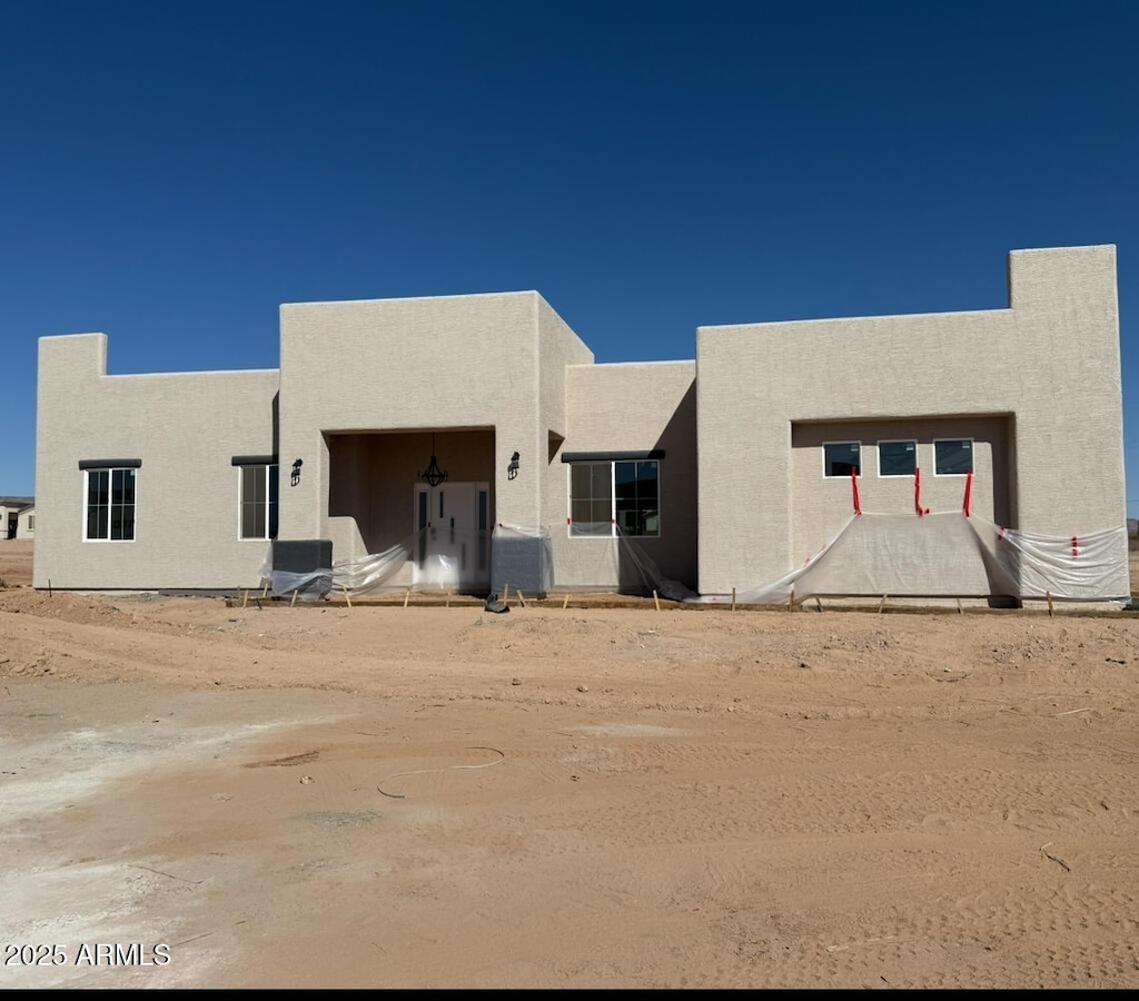 rear view of property with central AC and stucco siding