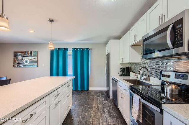 kitchen with white cabinets, dark wood-type flooring, decorative light fixtures, and appliances with stainless steel finishes