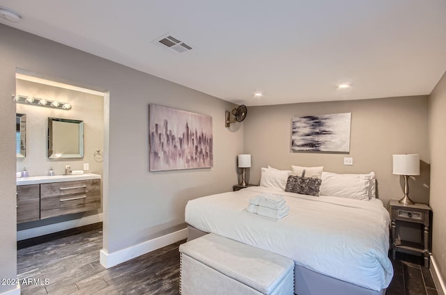 bedroom featuring ensuite bathroom and dark hardwood / wood-style floors