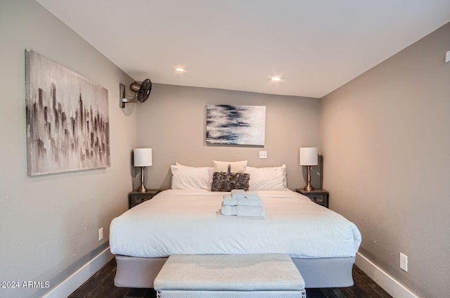 bedroom featuring dark wood-type flooring and vaulted ceiling