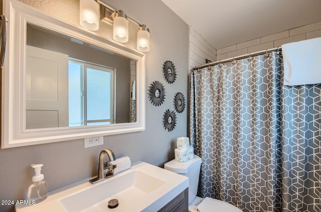 bathroom featuring a shower with curtain, vanity, and toilet