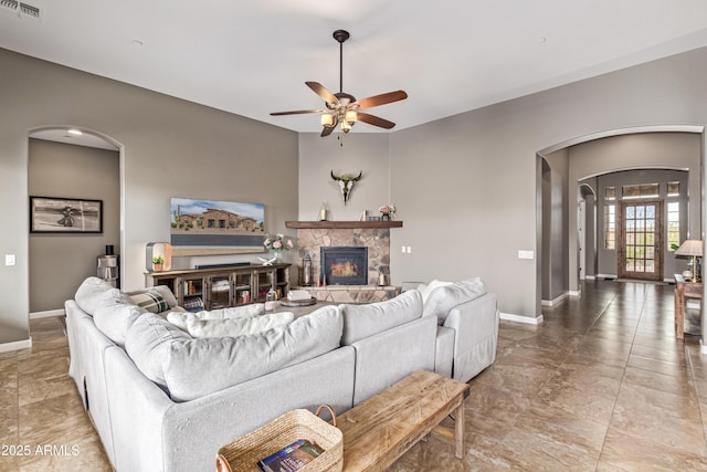 2255 N Hillridge, Mesa, AZ 85207 - living area with arched walkways, baseboards, ceiling fan, and a stone fireplace