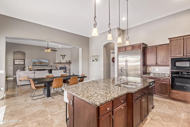 2255 N Hillridge, Mesa, AZ 85207 - kitchen featuring black appliances, arched walkways, a sink, a warm lit fireplace, and ceiling fan