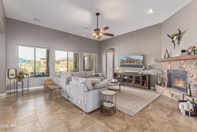 2255 N Hillridge, Mesa, AZ 85207 - living room featuring arched walkways, a stone fireplace, a ceiling fan, baseboards, and lofted ceiling
