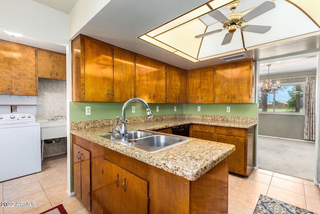 kitchen featuring ceiling fan with notable chandelier, washer / dryer, light tile patterned floors, and sink