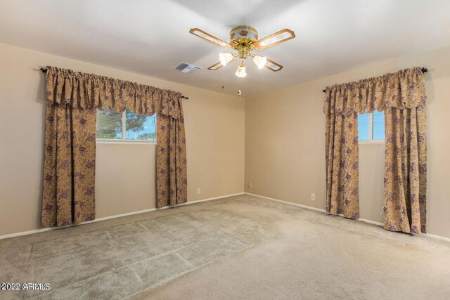 unfurnished room featuring carpet floors, plenty of natural light, and ceiling fan