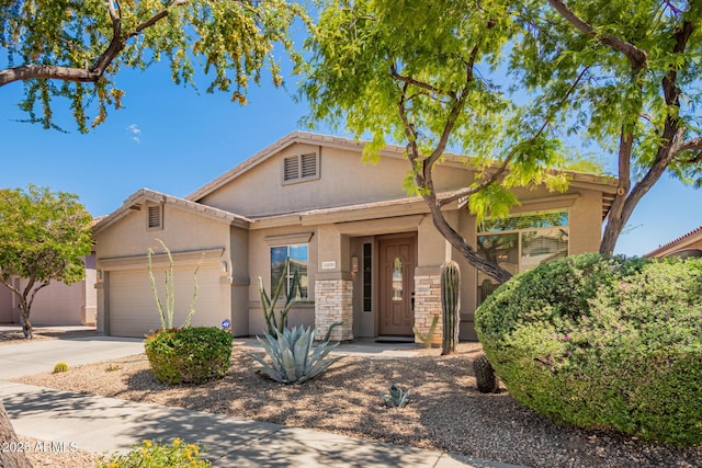 2409 W Red Range Way, Phoenix, AZ 85085 - view of front of property with stucco siding, a garage, concrete driveway, and stone siding
