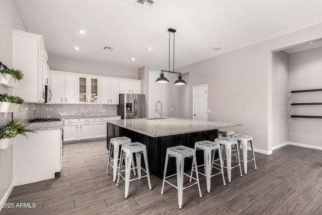 2409 W Red Range Way, Phoenix, AZ 85085 - kitchen with appliances with stainless steel finishes, a sink, light wood-type flooring, white cabinets, and decorative backsplash