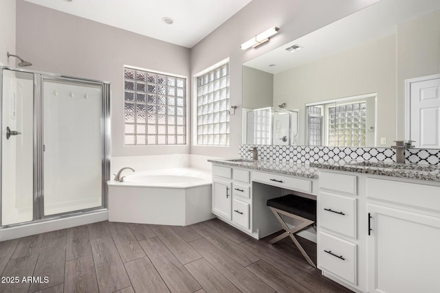 2409 W Red Range Way, Phoenix, AZ 85085 - bathroom with a shower stall, a bath, vanity, and decorative backsplash