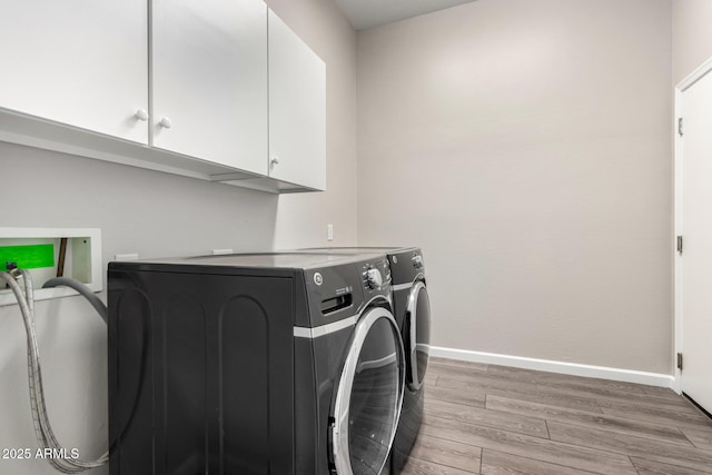 2409 W Red Range Way, Phoenix, AZ 85085 - clothes washing area featuring washer and clothes dryer, light wood-style floors, cabinet space, and baseboards