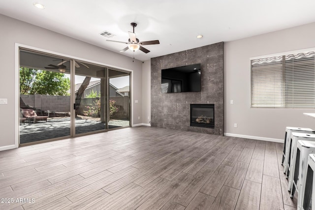 2409 W Red Range Way, Phoenix, AZ 85085 - unfurnished living room featuring ceiling fan, wood finished floors, baseboards, a fireplace, and recessed lighting