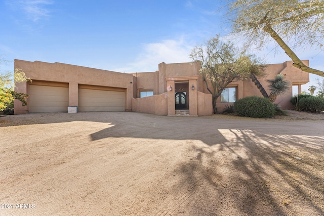 pueblo revival-style home featuring a garage