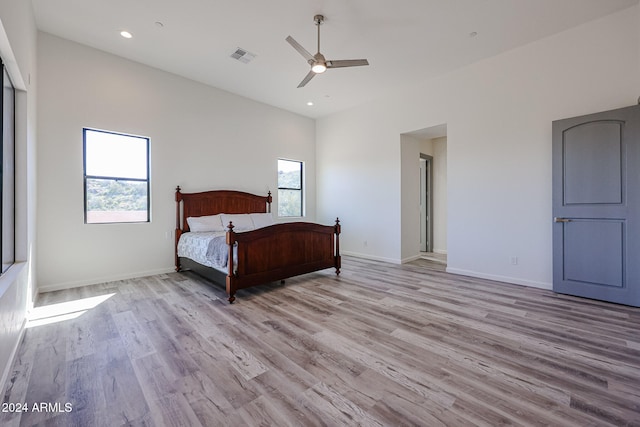 unfurnished bedroom featuring multiple windows, ceiling fan, and light hardwood / wood-style floors