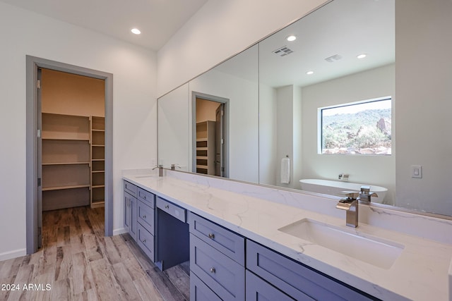 14914 E Zapata Dr, Fountain Hills, AZ 85268 - full bathroom featuring double vanity, wood finished floors, a freestanding tub, a spacious closet, and recessed lighting