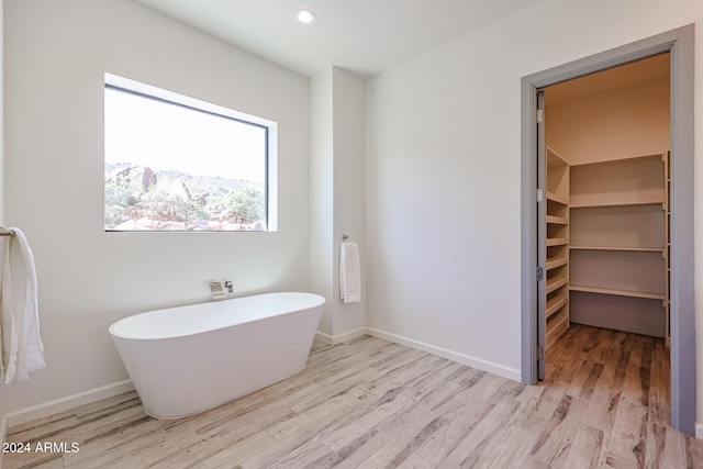 14914 E Zapata Dr, Fountain Hills, AZ 85268 - bathroom featuring wood finished floors, a freestanding bath, baseboards, recessed lighting, and a walk in closet
