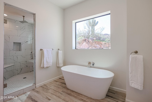 bathroom featuring plus walk in shower and wood-type flooring