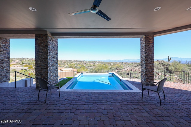 view of pool with ceiling fan, a mountain view, and a patio