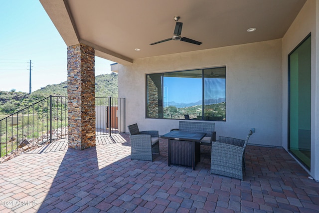 view of patio / terrace featuring ceiling fan, a mountain view, and an outdoor living space