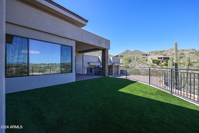 view of yard featuring a mountain view and exterior kitchen