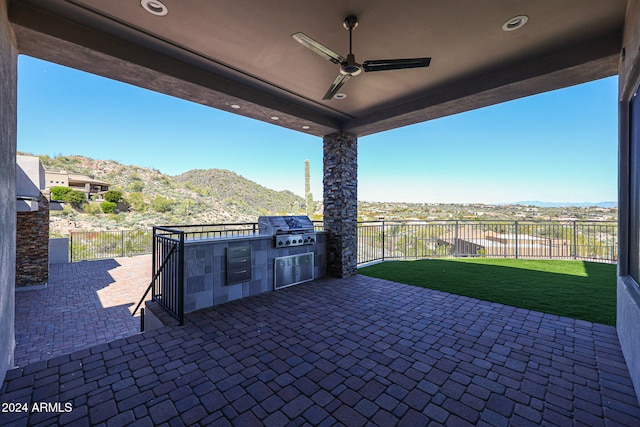 view of patio / terrace with a mountain view, ceiling fan, area for grilling, and a grill