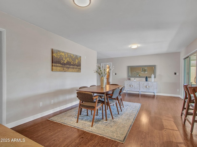 dining room with dark wood finished floors and baseboards