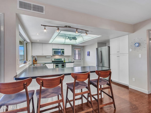 kitchen with white cabinetry, visible vents, stainless steel appliances, and a sink