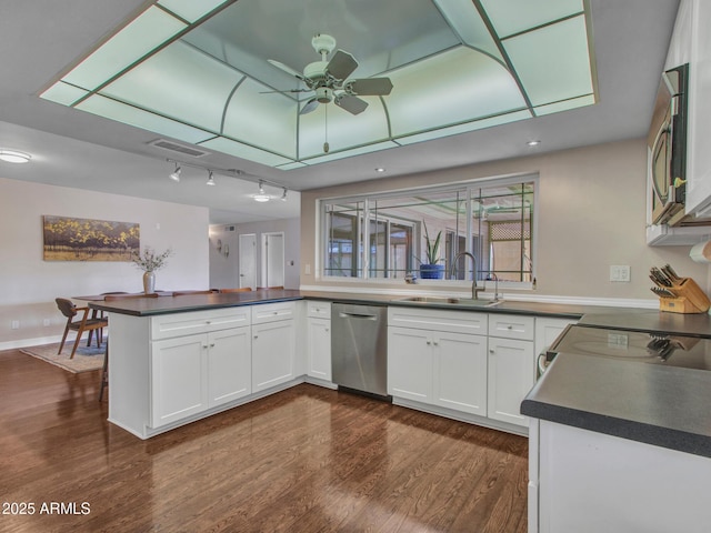 kitchen featuring a peninsula, stainless steel appliances, visible vents, white cabinetry, and dark countertops