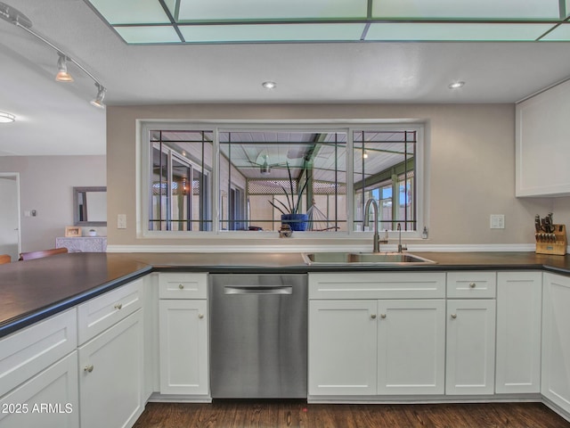 kitchen featuring dark countertops, a sink, white cabinets, and stainless steel dishwasher