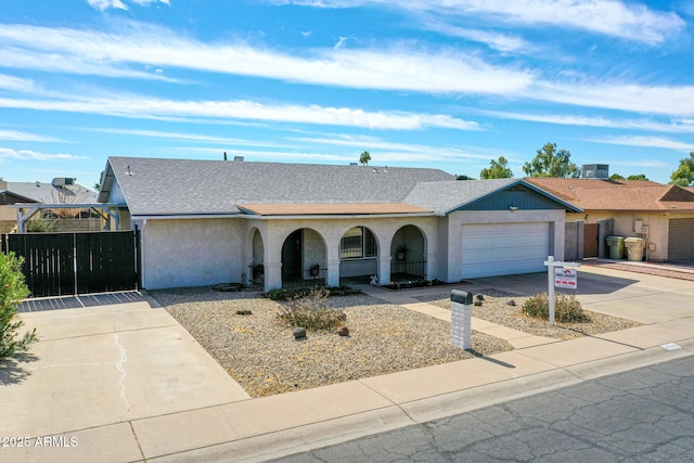 single story home featuring stucco siding, a shingled roof, an attached garage, fence, and driveway